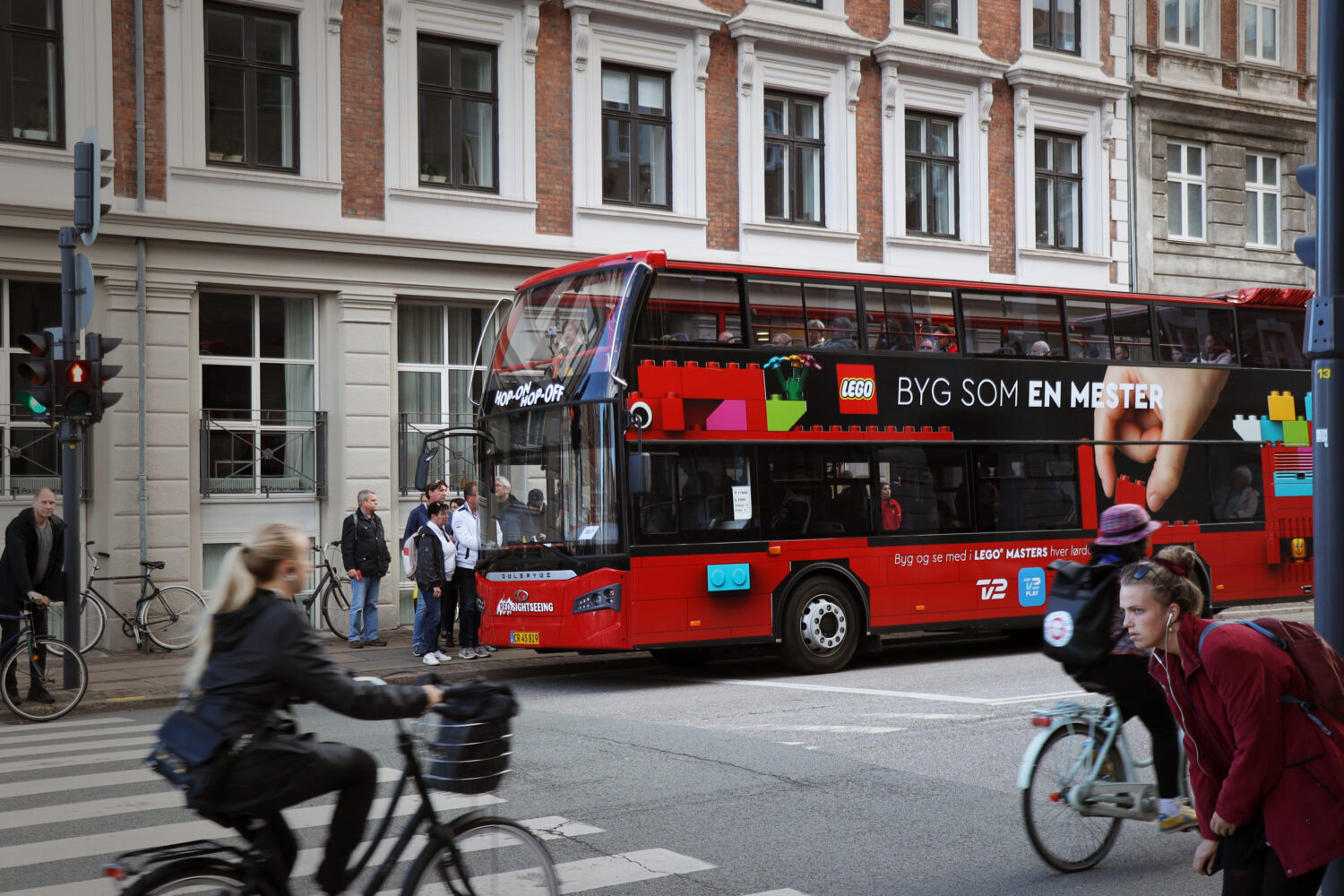 Busreklame for LEGO 'Byg som en mester' på en dobbeltdækker sightseeing-bus i Københavns centrum